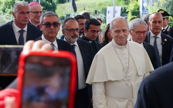 Pope Leo XIV smiles as a person takes a cellphone photo as the pontiff arrives at Rome's Gemelli Hospital Oct. 13, 2026, ahead of his surgery that afternoon to remove a lung nodule.