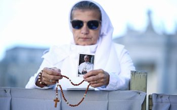 A nun holds an image of Pope Leo XIV while praying with rosary as Cardinal Luis Antonio Tagle, pro-prefect of the Dicastery for Evangelization, celebrates a Mass in St. Peter's Square at the Vatican Oct. 14, 2026, on the final day of the meeting in which the presidents of bishops' conferences are marking the 10th anniversary of "Amoris Laetitia" ("The Joy of Love").
